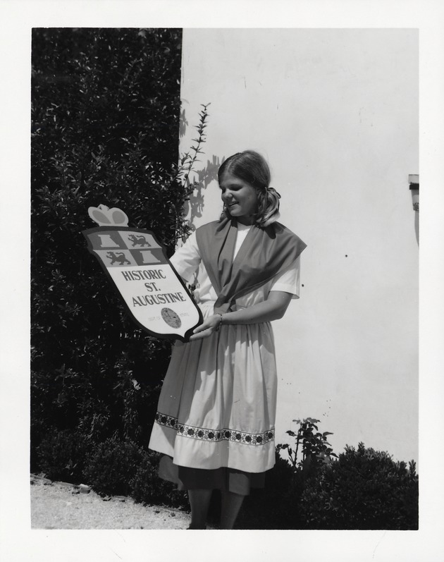 Linda Dean holding up a plaque for Historic St. Augustine, 1970