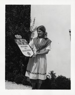 [1970] Linda Dean holding up a plaque for Historic St. Augustine, 1970