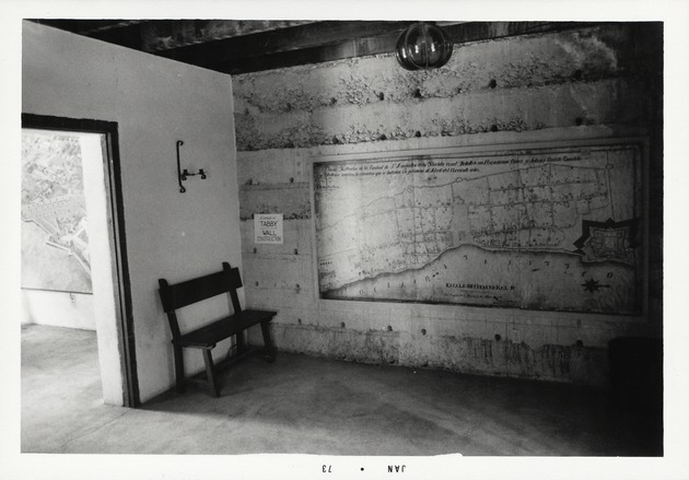 Exposed tabby wall inside the Gallegos House used to teach visitors about tabby construction, along with a large reproduction of the Rocque Map, looking North, 1973