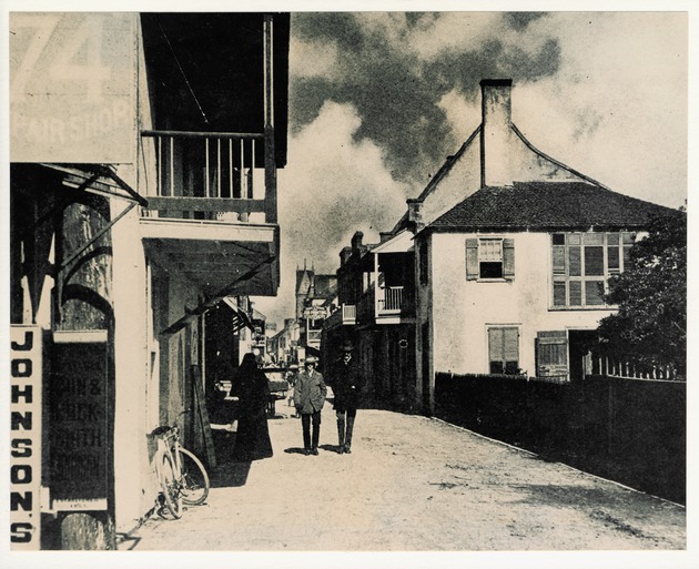 Two men walking down St. George Street with a view of the Benet House on the right, looking North
