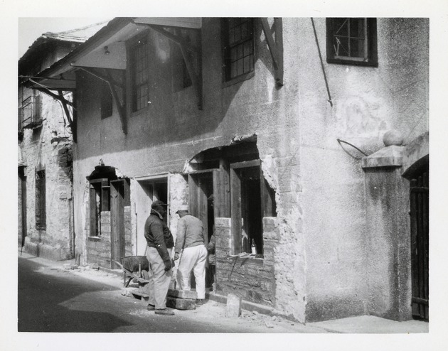 Restoration work on the De Mesa Sanchez House from St. George Street, patching coquina masonry on the West facade, 1955 - 