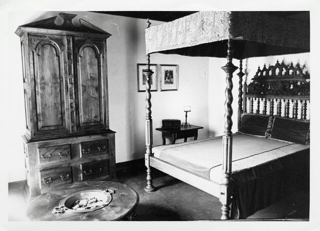 A bed, armoire, and charcoal brazier in a bedroom of the De Mesa Sanchez House, 1970