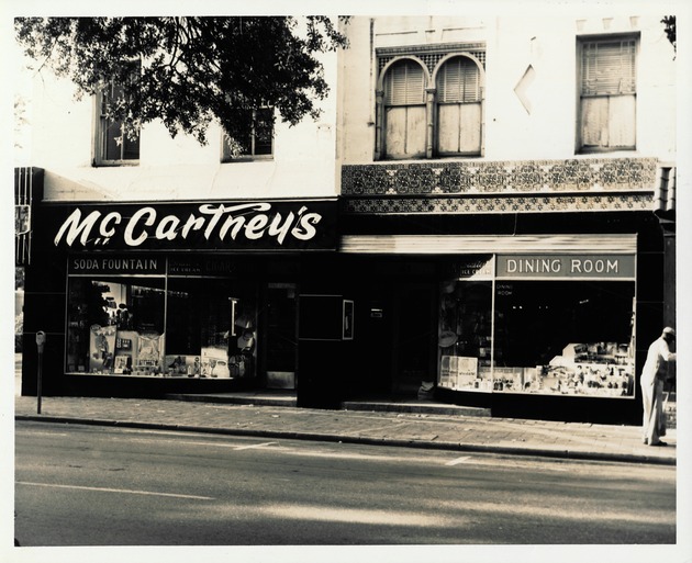 Individual shops along the Lyons Building and Cordova Building as seen from King Street looking South, from east to west, 1960 - McCartney's Drug Store, Northeast corner of the Lyon Building, on the corner of King Street and St. George Street