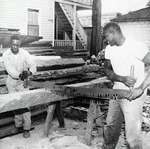 George Washington (left) and Sam Rowe operating a two-man saw during the construction of the Old Blacksmith Shop on the Judson Property, 1967