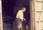 Coco Mickler working on a length of chain at the Old Blacksmith House, ca. 1968