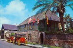 Large postcard of the Oldest House with two horse-drawn carriages out front from St. Francis Street, looking Northwest, ca. 1970s