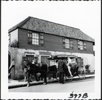 A horse-drawn carriage loading passengers in front of the Oldest Houe from St. Francis Street, looking Northeast, ca. 1960