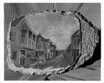 Painting on the stucco on a piece of coquina stone entitled "Charlotte Street, St. Augustine, 1891" showing Charlotte Street at Baya Lane, looking North