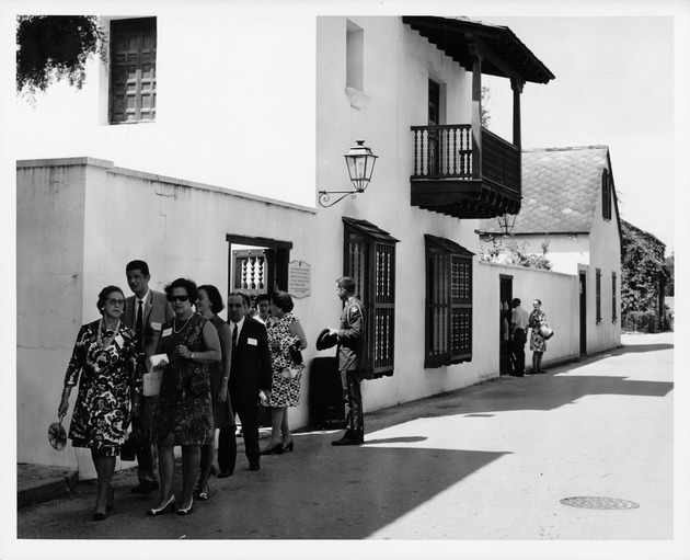 The delegation exiting the Ribera House while touring the restoration area, looking Northwest, 1969