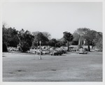 The parking lot for the Oldest Wooden School House (Genopoly House) and the City Gate in the background, as seen from the grounds of the Castillo de San Marcos looking over Avenida Menendez (Bay Street), looking Northwest, ca. 1971