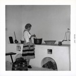 Woman in period dress cooking in the kitchen of the Ribera House, 1967