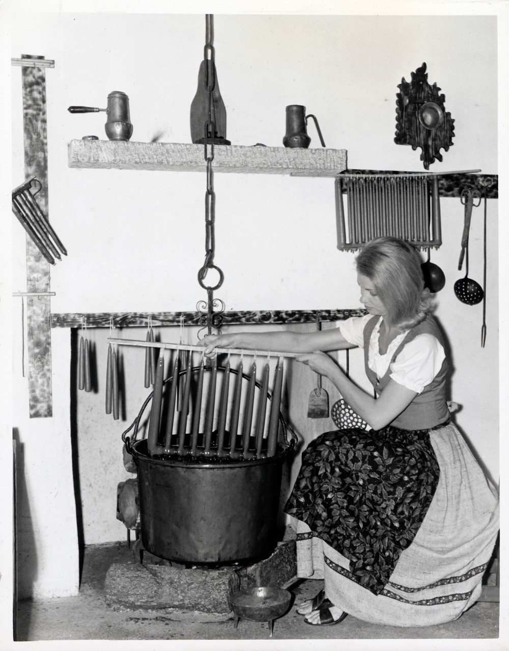 A promotional photograph showing a woman in period clothing dipping candles in Arrivas House - 