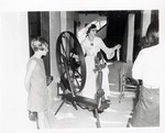Priscilla Johns demonstrates spinning in Arrivas House with a young girl and woman watching in the foreground