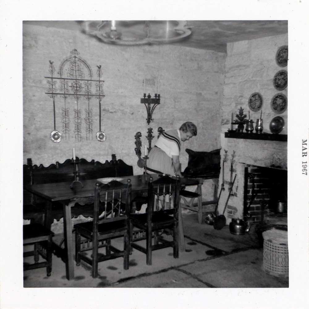De Mesa Sanchez House interior (as Old Spanish Inn), woman tending artifacts, 1967