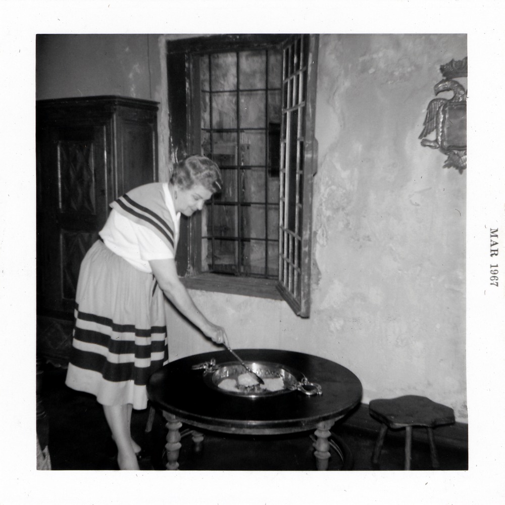 De Mesa Sanchez House interior (as Old Spanish Inn), woman tending charcoal brazier, 1967