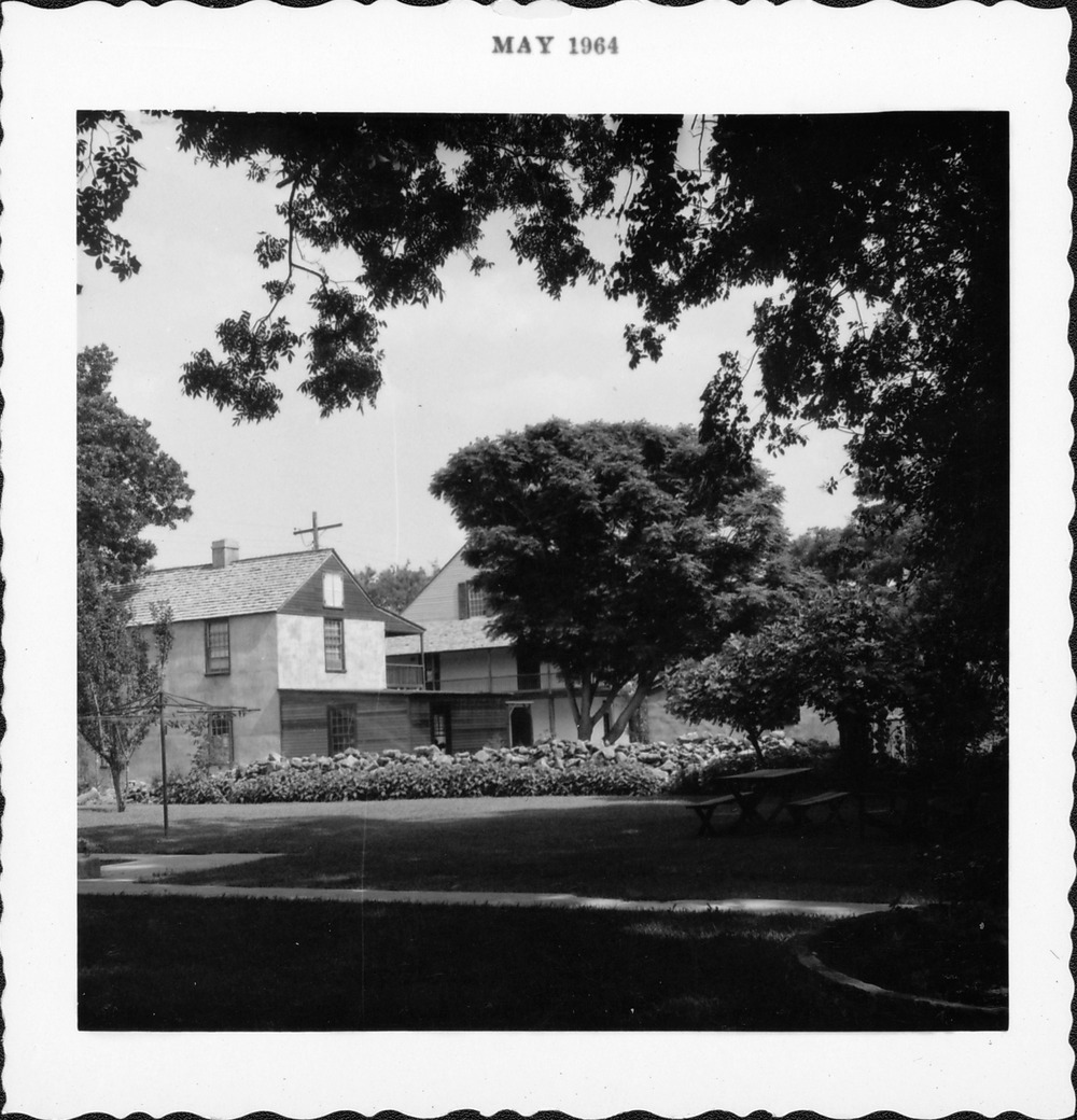 Photo taken behind public restrooms looking North toward Salcedo House (on left) and Arrivas House (behind), photo has been mistakenly mounted in book under Benet House