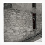 Views showing the coquina under the stucco on the first story of the Benet Store, July 1967