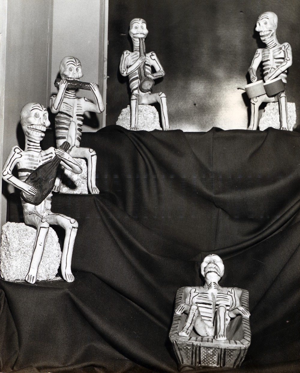 Ceramic skeletons (calaveras) playing instruments on display in Government House, 1967