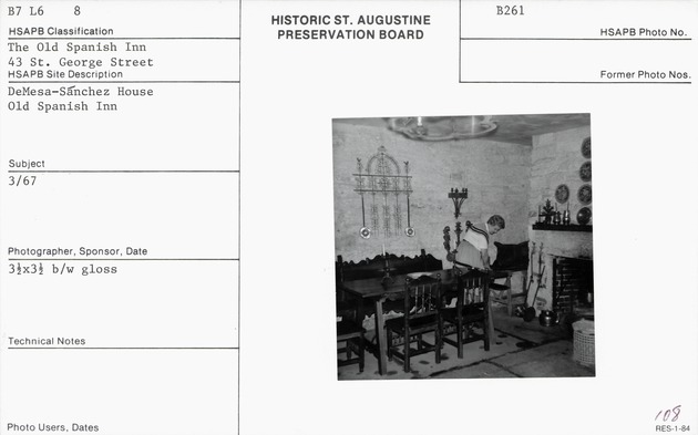 Woman in period dress tending artifacts in the kitchen of the De Mesa Sanchez House (Room 110)