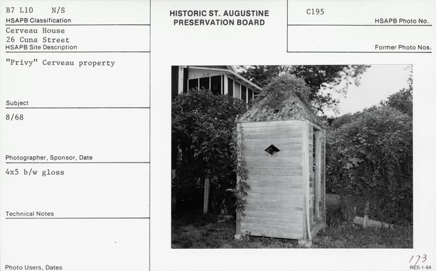 Outhouse (privy) in the rear yard of the Cerveau House, looking West, with the roof line of the Haas House visible in the upper left corner